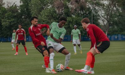 Soccer players battling for ball on field