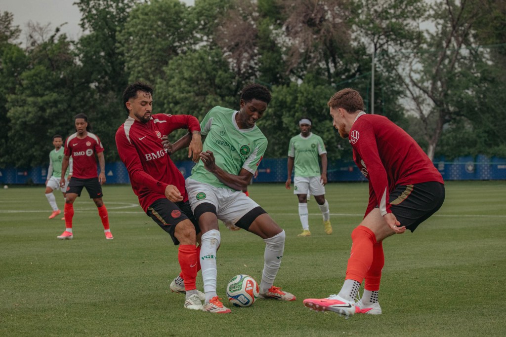 Soccer players battling for ball on field