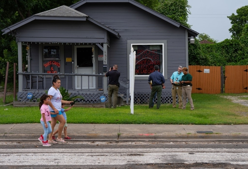 Police outside psychic reading house as family walks by