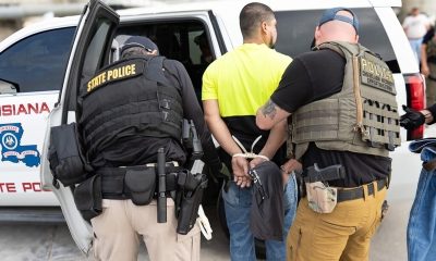 State police arresting man beside patrol vehicle