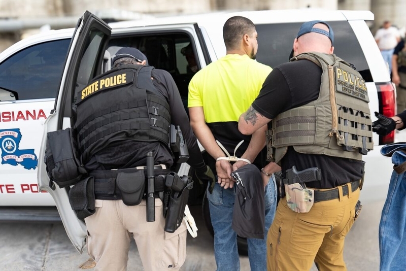 State police arresting man beside patrol vehicle
