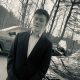 Young man in suit beside parked cars outdoors