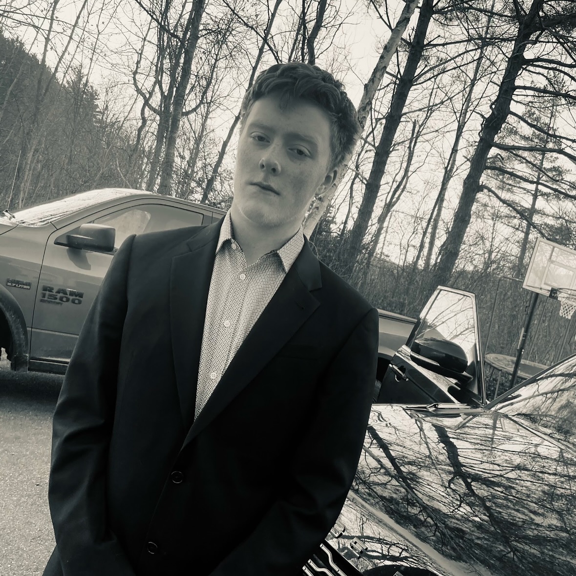 Young man in suit beside parked cars outdoors
