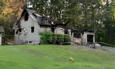 Fire-damaged house with caution tape and charred roof