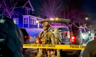 Armed police officers behind crime scene tape at night