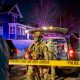 Armed police officers behind crime scene tape at night