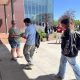 People exchanging flyer outside campus building