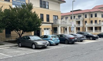 Apartment complex with parked cars and leasing sign