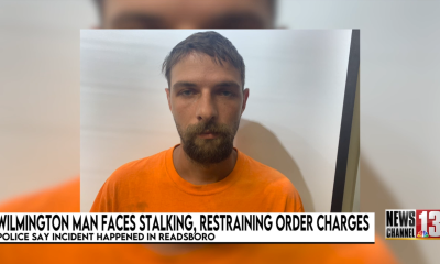 Man in orange shirt in police mugshot