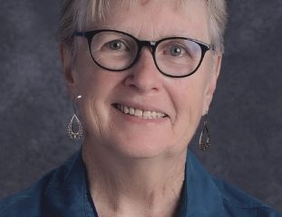 Smiling older woman with glasses in studio portrait