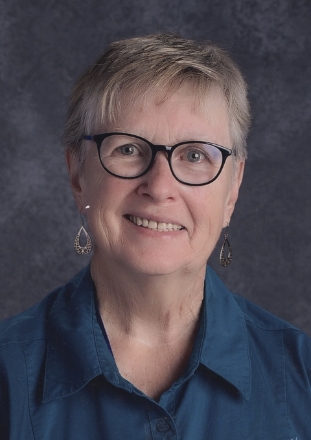 Smiling older woman with glasses in studio portrait
