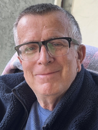 Older person wearing glasses smiling indoors