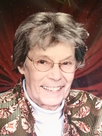 Smiling elderly woman with glasses and patterned jacket