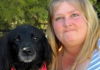 Woman posing with black dog wearing red bandana