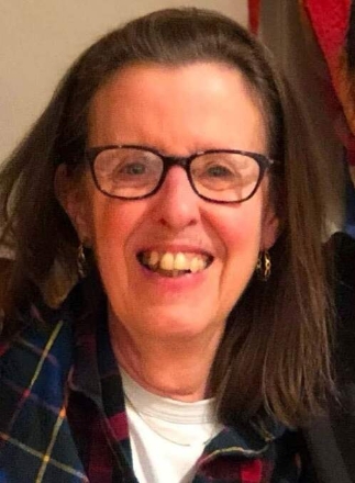 Smiling woman with glasses and plaid scarf