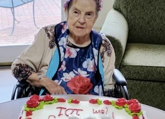 Elderly woman with birthday cake and party hat
