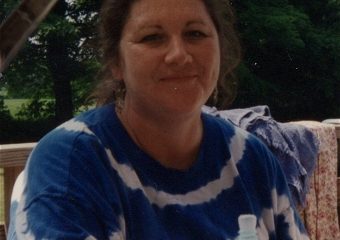 Woman sitting outdoors on wooden deck