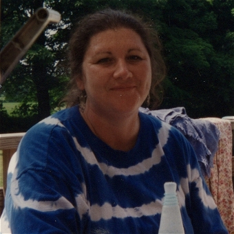 Woman sitting outdoors on wooden deck