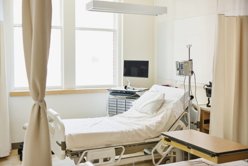 Empty hospital room with bed and equipment