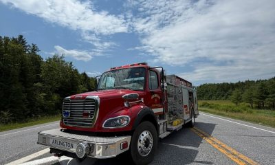 Red fire engine on rural road under blue sky