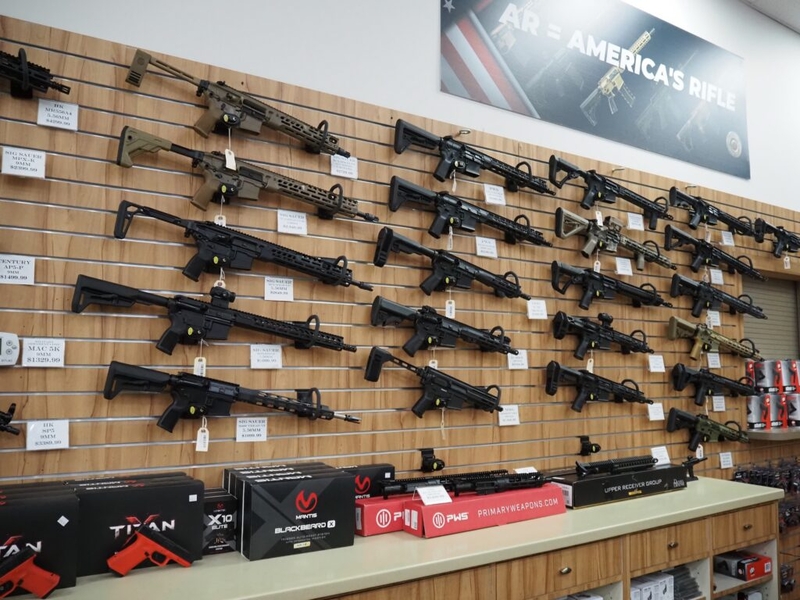 Wall display of AR-style rifles in gun store