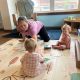 Woman playing with two toddlers on play mat