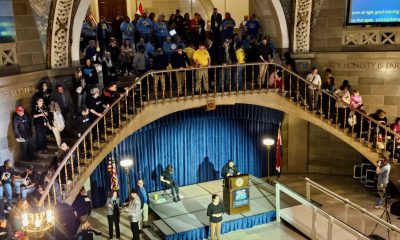 Speaker at podium in crowded capitol rotunda