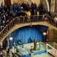 Speaker at podium in crowded capitol rotunda