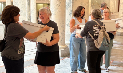 Women carrying document boxes inside marble government building
