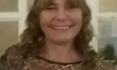 Smiling woman wearing decorative gold-patterned top indoors