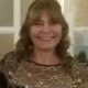 Smiling woman wearing decorative gold-patterned top indoors