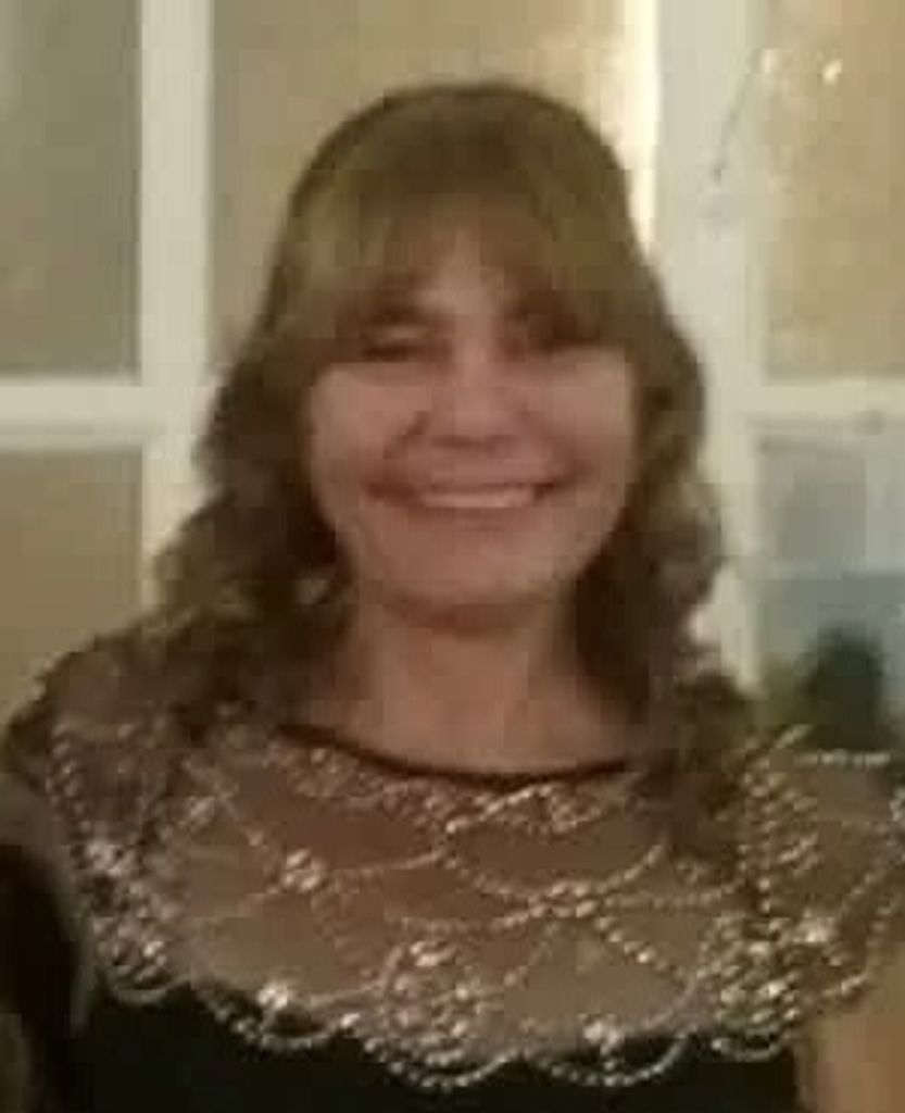 Smiling woman wearing decorative gold-patterned top indoors