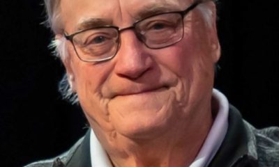 Elderly man wearing glasses and zip-up sweater