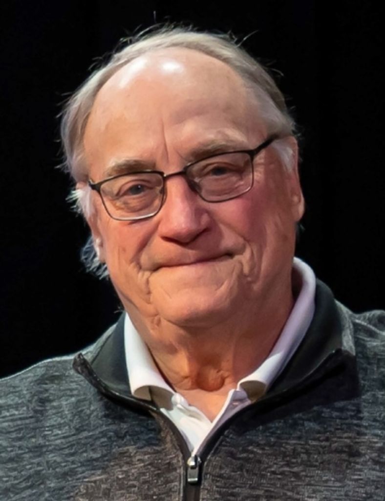 Elderly man wearing glasses and zip-up sweater