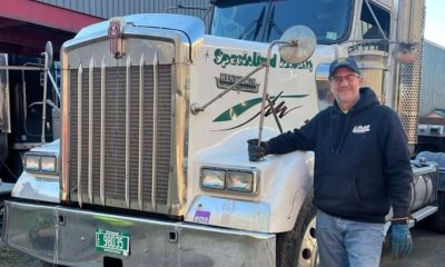Man standing beside large white semi-truck