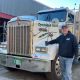 Man standing beside large white semi-truck