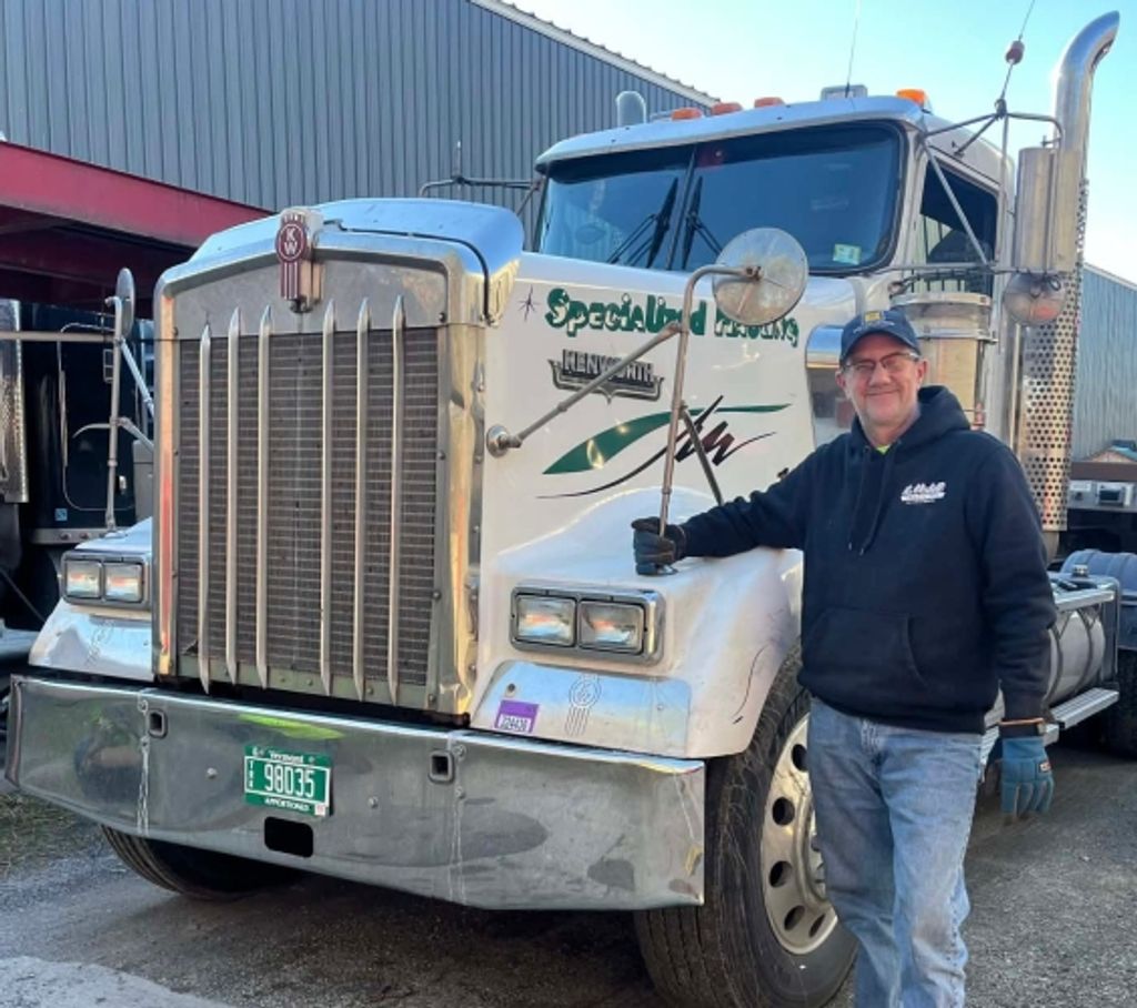 Man standing beside large white semi-truck