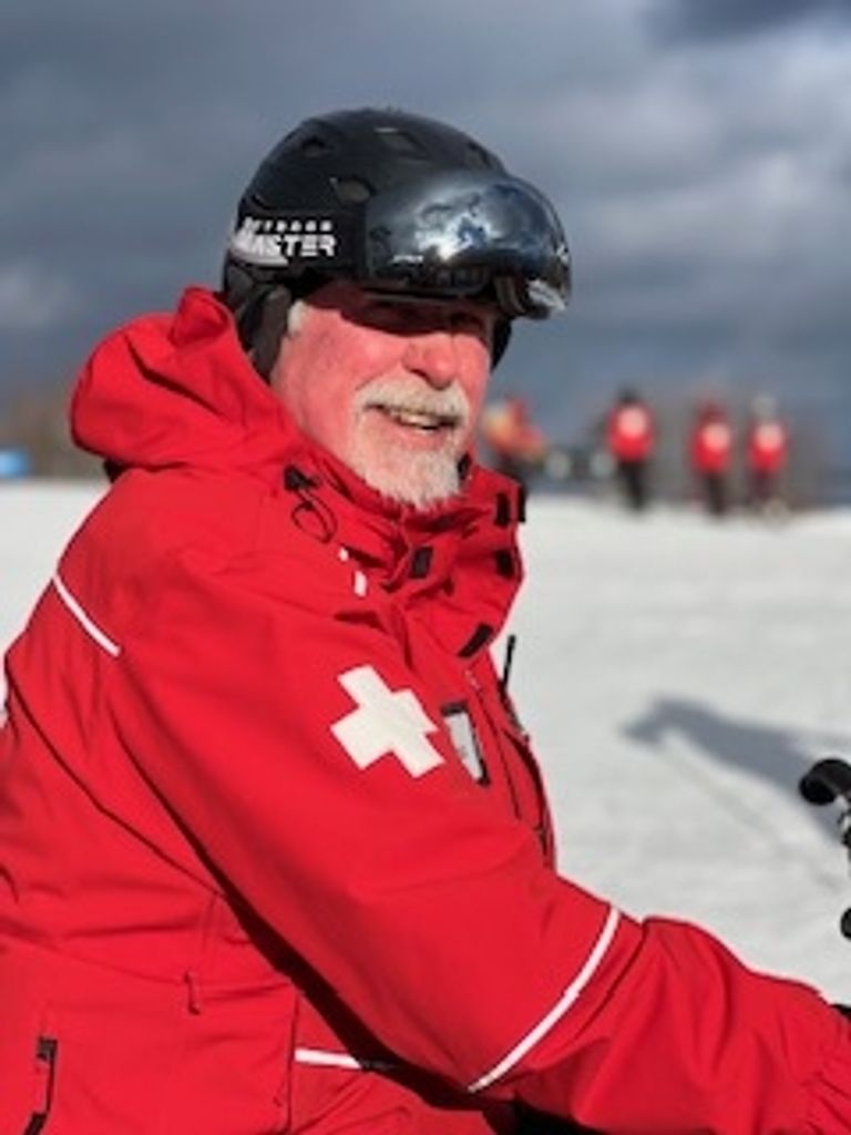 Ski patrol member in red jacket on snow