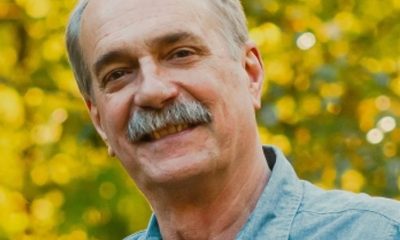 Smiling man outdoors with autumn foliage background