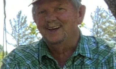 Smiling older man in green plaid shirt outdoors