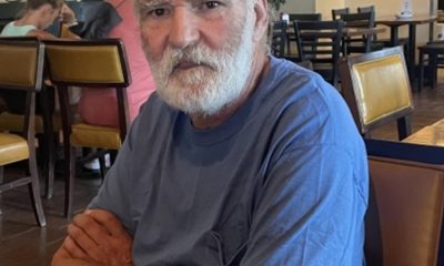 Older man with white beard sitting at restaurant