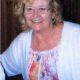 Smiling woman with glasses in floral blouse