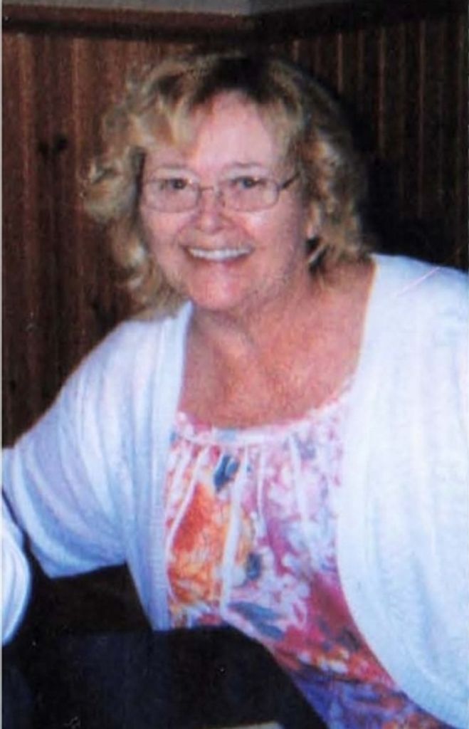 Smiling woman with glasses in floral blouse