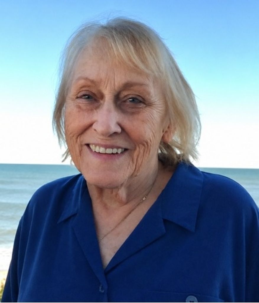 Smiling elderly woman at beach with ocean backdrop