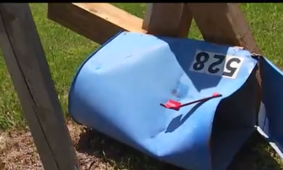 Damaged blue mailbox lying on the ground
