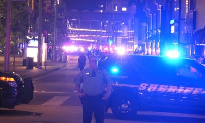 Sheriff deputy standing by patrol cars at night