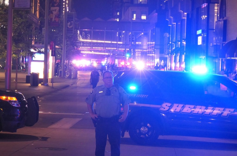 Sheriff deputy standing by patrol cars at night