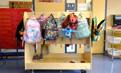 Colorful children's backpacks hanging on school rack