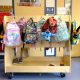 Colorful children's backpacks hanging on school rack