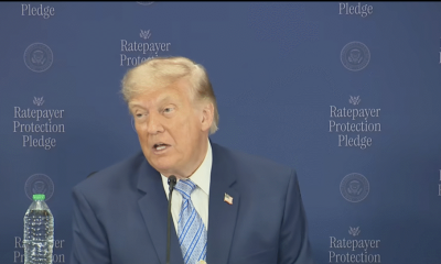Man speaking at podium with blue backdrop